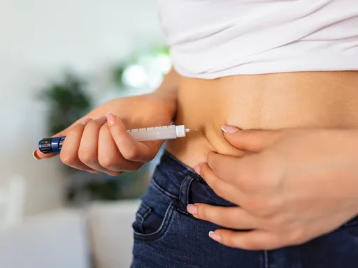 Close-up of a person using a pen-style Tirzepatide injector on their abdomen, conveying routine self-care and calm focus.